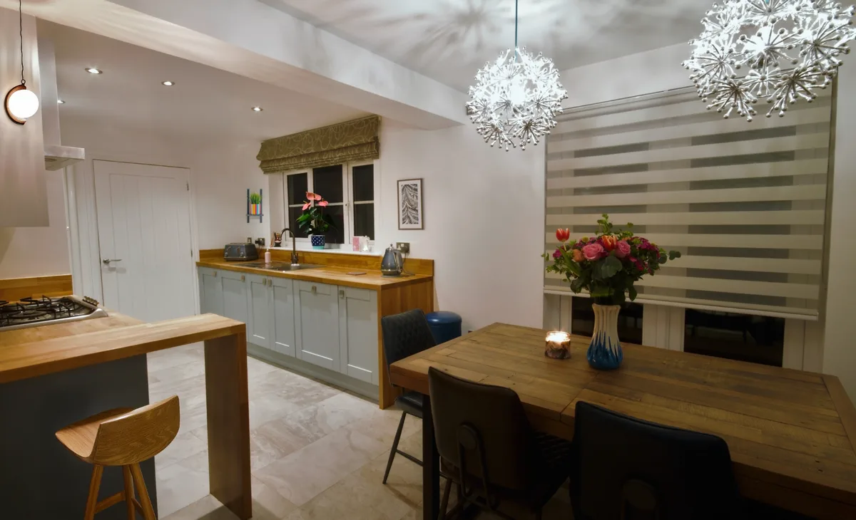 Inviting kitchen-dining space with warm wood tones and statement lighting